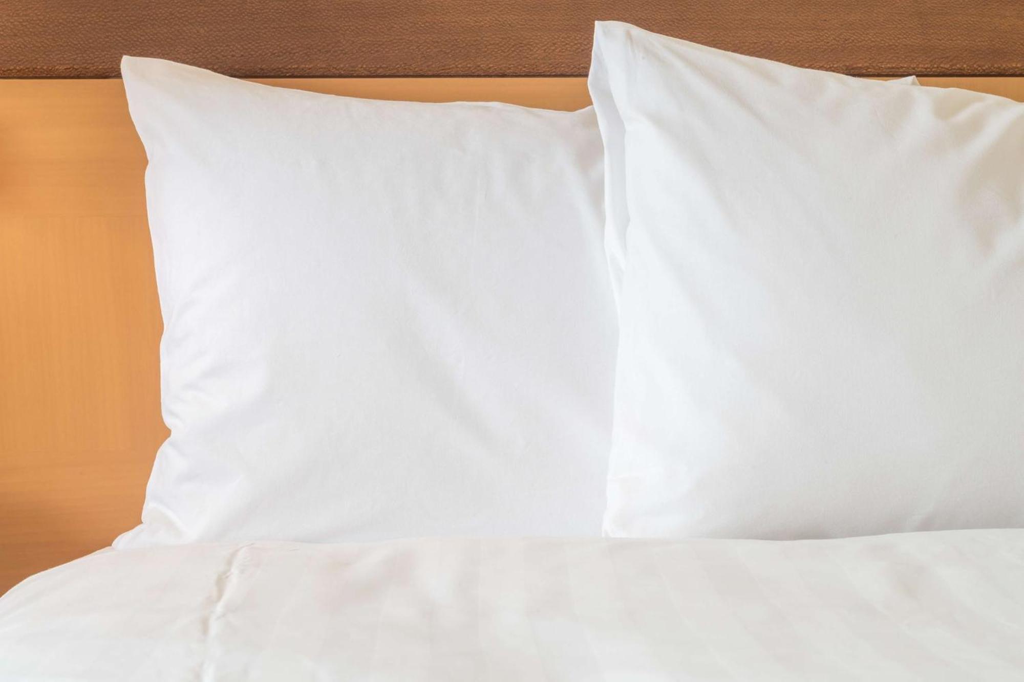 Crowne Plaza Tainan By Ihg Hotel Exterior photo Two pillows on a bed
